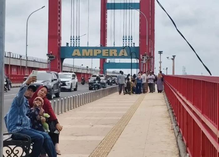 Berfoto dengan Latar Jembatan Ampera